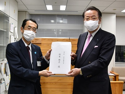 東京都坂本産業労働局長（左）に意見を手交する金子委員長