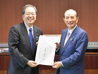 斉藤大臣（左）に要望書を手交する野本副会頭