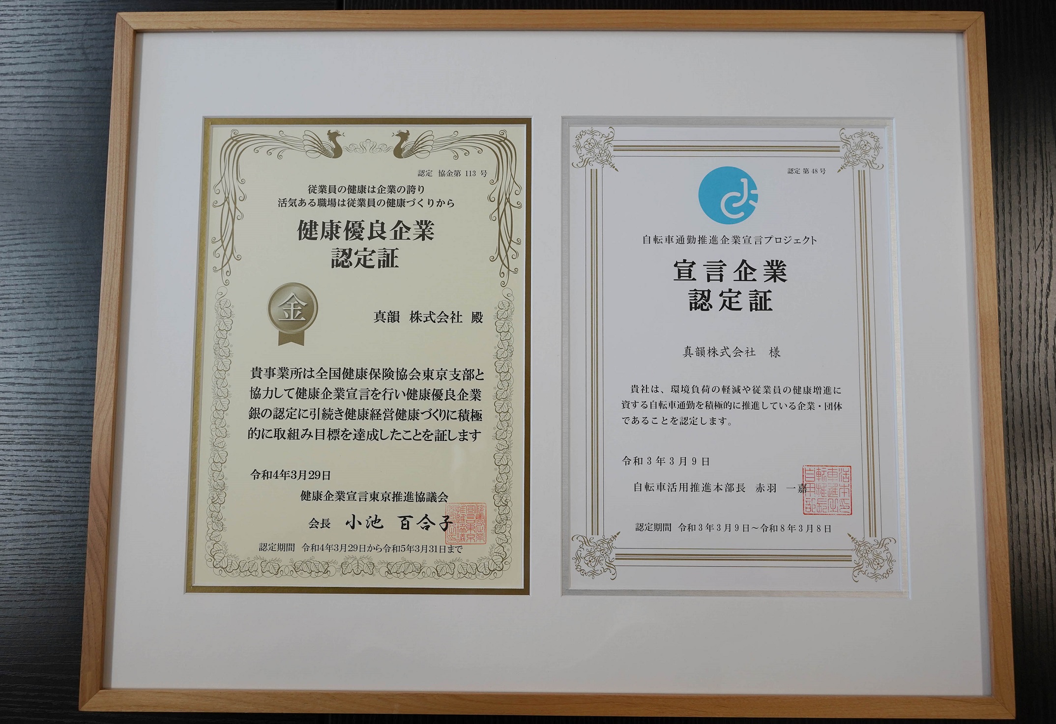 健康優良企業「金の認定」認定証（左）と、自転車通勤推進企業宣言プロジェクトの認定証