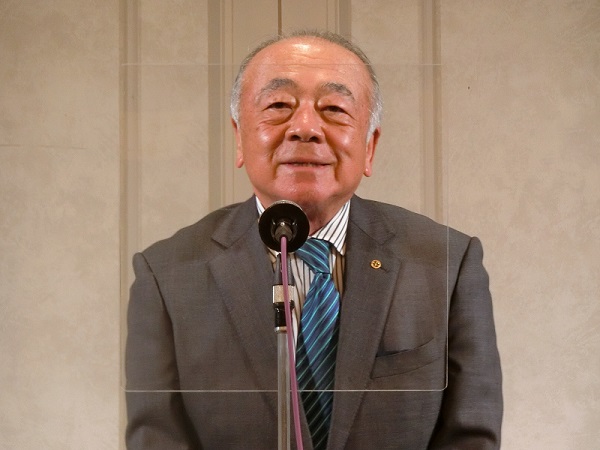 あいさつする吉岡会長