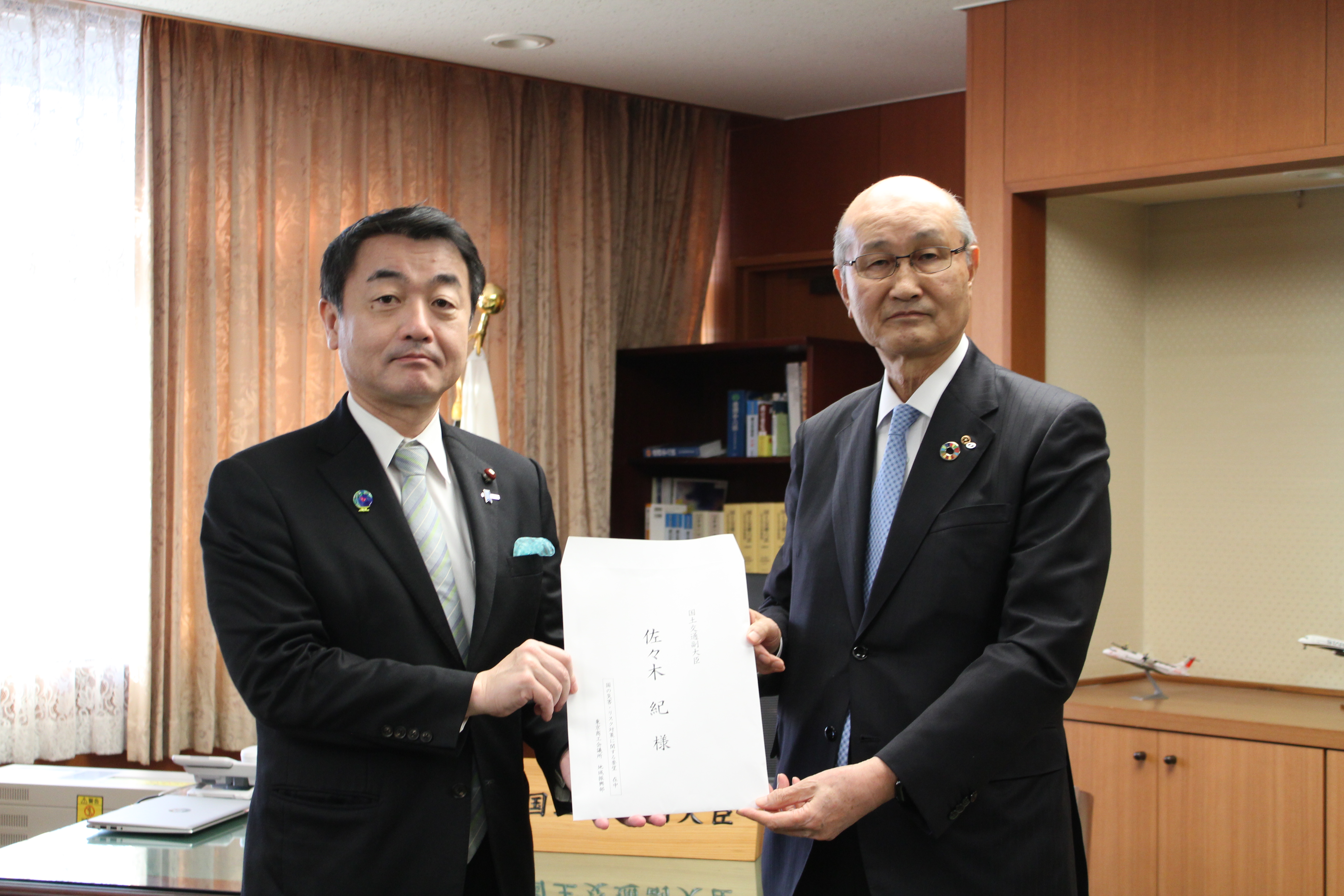 佐々木国土交通副大臣に要望書を手交する宮本委員長（右）