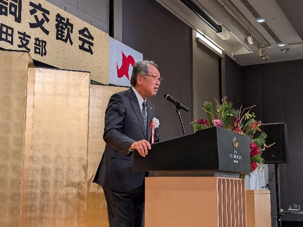 挨拶する岩﨑会長