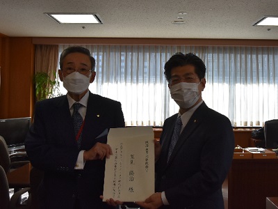里見経済産業大臣政務官（右）に提言書を手交する朝田委員長（左）