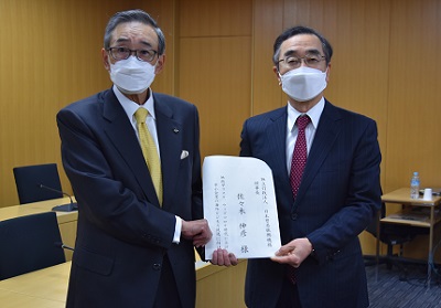 佐々木理事長（右）に提言書を手交する朝田委員長（左）