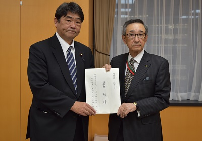 藤丸内閣府副大臣（左）に提言書を手交する朝田委員長（右）