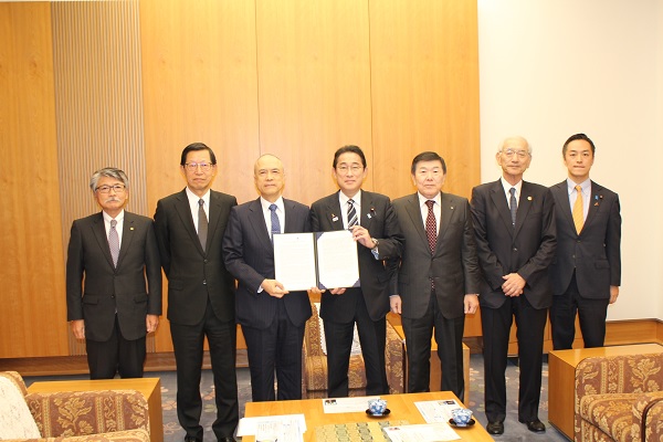 採択された共同声明を手に持つ岸田首相（中央）と広瀬委員長（中央左）