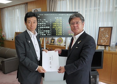 西村内閣府副大臣（左）へ要望書を提出する大久保委員長（右）