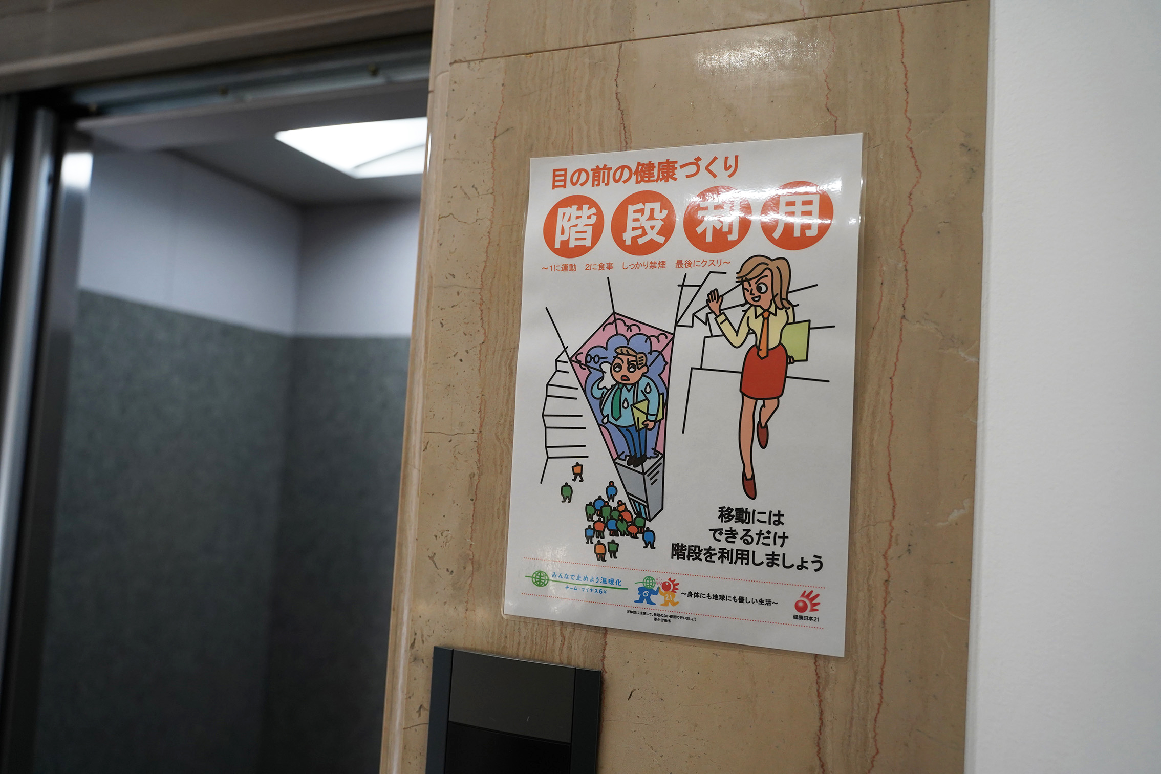 エレベーターの入り口横には、階段利用を促すポスターを掲示